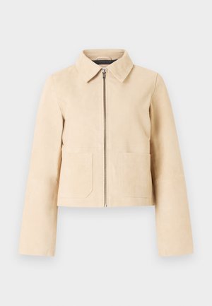 Beige cropped jakke med lange ærmer, spids krave, frontlynlås og to forlommer på en lys baggrund.