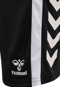 Black athletic shorts featuring white side panels and a chevron pattern. Includes Hummel branding in white at the lower hem.