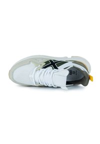 Zapatilla con parte superior de malla blanca, acentos de ante gris, logo negro y verde oliva, y un tirador amarillo; presenta cordones blancos y detalles perforados.