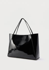 Fekete, fényes lakkozott kézitáska sima felülettel, nyitott tetejű, két vállpánttal, szögletes oldalakkal és tágas belső térrel.