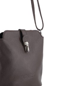 Brązowa skórzana torebka o teksturowanym wykończeniu, z zapięciem ze srebrnym okuciem oraz jednym odczepianym paskiem. Wytłoczone logo z przodu.