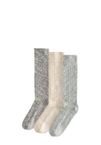 Trois paires de chaussettes en tricot : gris, beige et vert clair, présentant un design côtelé et une finition légèrement texturée, adaptées à un usage décontracté.