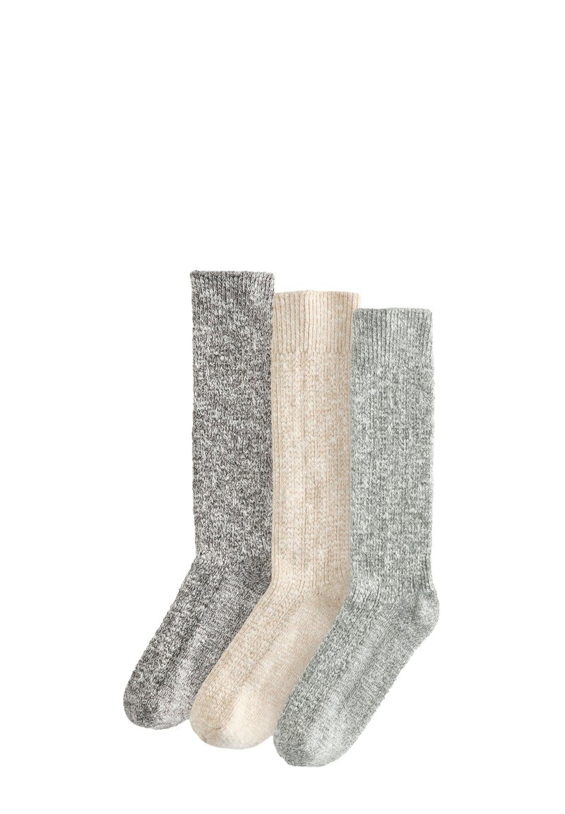 Trois paires de chaussettes en tricot : gris, beige et vert clair, présentant un design côtelé et une finition légèrement texturée, adaptées à un usage décontracté.