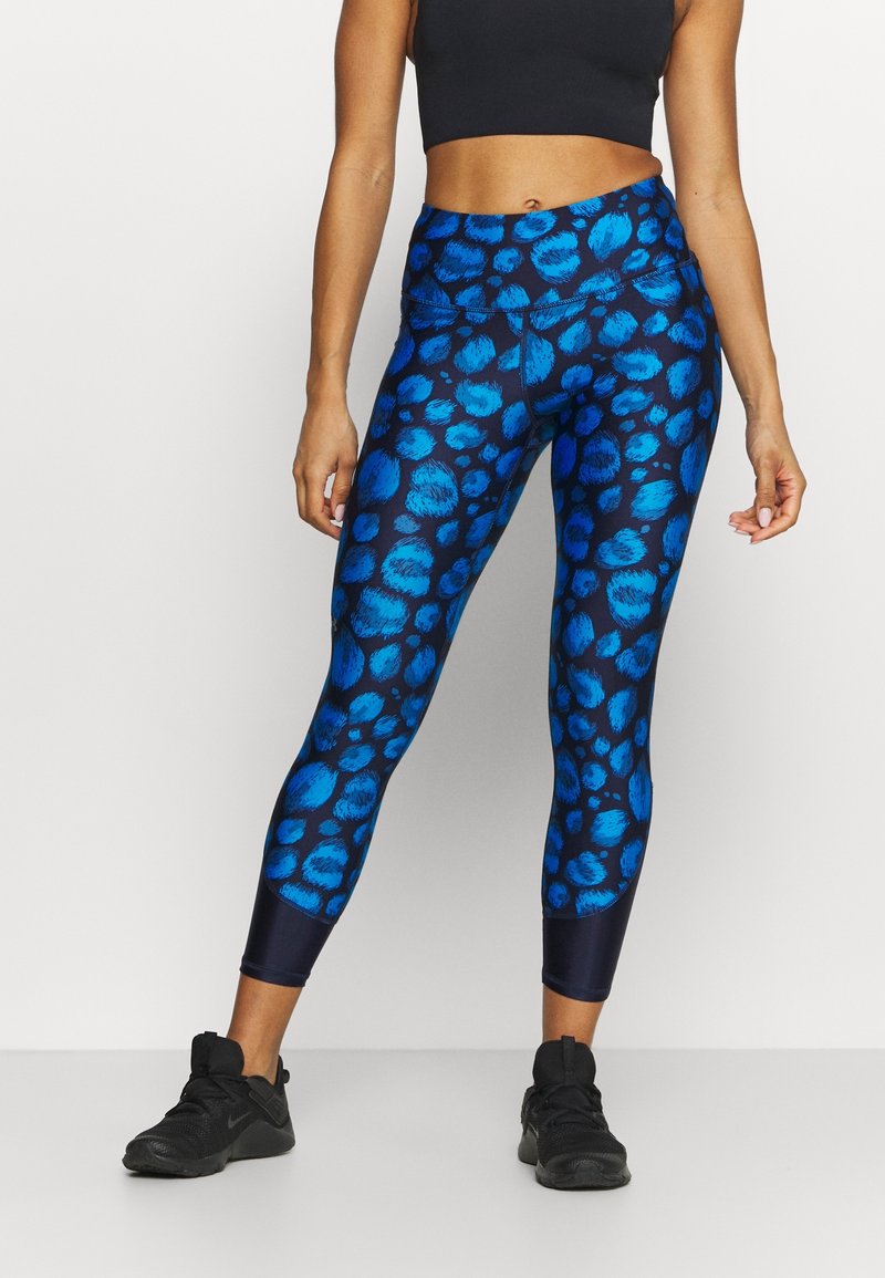 Blå leopardmönstrade leggings med hög midja, tillverkade av stretchmaterial, med en slät yta och kontrasterande mörkblå accenter.