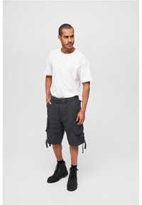 Black cargo shorts with multiple side pockets, paired with a plain white t-shirt and black lace-up boots. Simple, casual design.
