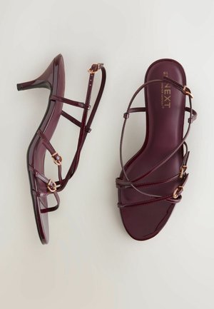 Burgundia patendinahast kingad kõrguse ja õhukeste rihmadega ning roosakuldse riistvaraga. Omab sirget avatud varba ja suletud kanna disaini.