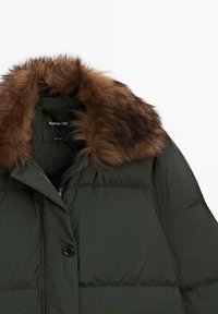 Dark green padded winter coat with brown fur collar and black button closure, shown from the upper chest to collar area.