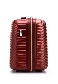 Valigia rigida di colore rosso intenso con finitura lucida, caratterizzata da una texture rigata, una cerniera dorata e un elegante manico metallico.