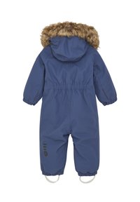 Blå vattentät overall med fuskpälsfodrad huva, elastisk midja och ärmslut. Har fotremmar och svart logotypdetalj på benet.