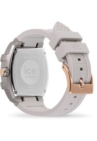 Montre Ice avec un bracelet en silicone gris et un boîtier en acier inoxydable, présentant un bracelet texturé et une quincaillerie en or rose. Le dos présente des détails gravés.