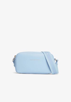 Jasnoniebieska prostokątna torba na ramię z złotym zamkiem błyskawicznym, regulowanym szerokim paskiem i małym srebrnym logo "Tommy Hilfiger" z przodu.