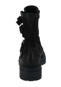 Botín negro de cuero hasta el tobillo con múltiples hebillas ajustables de plata, punta redondeada y superficie texturizada con una suela de goma gruesa.