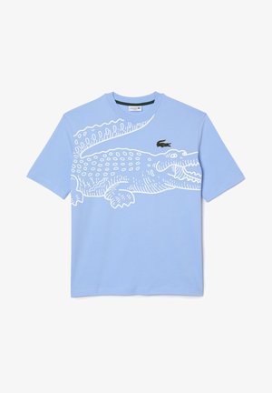 T-shirt bleu clair à manches courtes avec un grand dessin au trait blanc représentant un crocodile et un petit logo crocodile vert sur la poitrine.