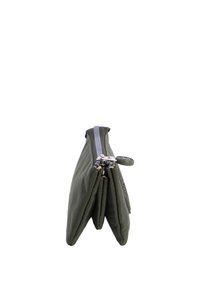 Bolsa de tela verde con una textura suave, que cuenta con un cierre de cremallera en la parte superior, dos compartimentos y una etiqueta decorativa en la cremallera.