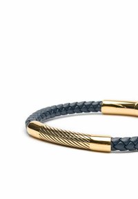 Flätad mörkblå läderarmband med guldfärgade metalldelar som har en vriden design, vilket framhäver en elegant kontrast mellan materialen.