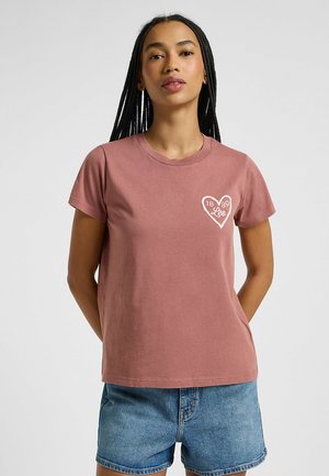 Rosa bomulds t-shirt med rund hals, korte ærmer og hvid hjertegrafik med teksten "1889 Lee" på venstre bryst.