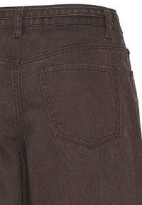 Pantalon en denim marron foncé montrant la poche arrière, les passants de ceinture et les détails de couture.
