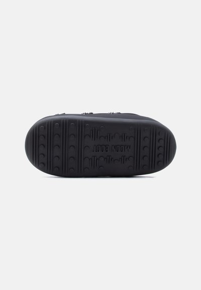 Μαύρη αντιολισθητική σόλα παπουτσιού με υφασμένη επιφάνεια από καουτσούκ, διακοσμημένη με κυκλικά σχέδια λαβής και ανάγλυφο λογότυπο. Καμπυλωτή μύτη και συμπαγής σχεδιασμός.