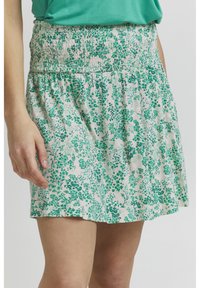 Hame skirt floral dengan pinggang smocked, menampilkan desain botani hijau di latar belakang yang terang, terbuat dari kain yang lembut dan ringan.