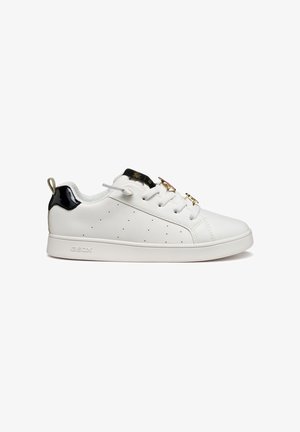Baskets blanches avec un design perforé, accents en vernis noir, fermeture à lacets, détails en métal doré et semelle en caoutchouc. Logo de la marque affiché.