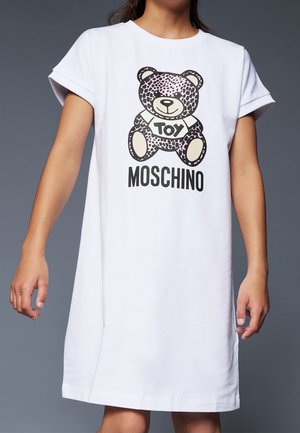 Hvid t-shirt kjole med korte opsmøgede ærmer, prydet med et grafik af en leopardmønstret bjørn med teksten "TOY MOSCHINO" i sort.