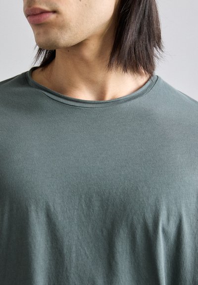Dark green cotton T-shirt featuring a round neckline and short sleeves, with a soft texture and minimal wrinkles.