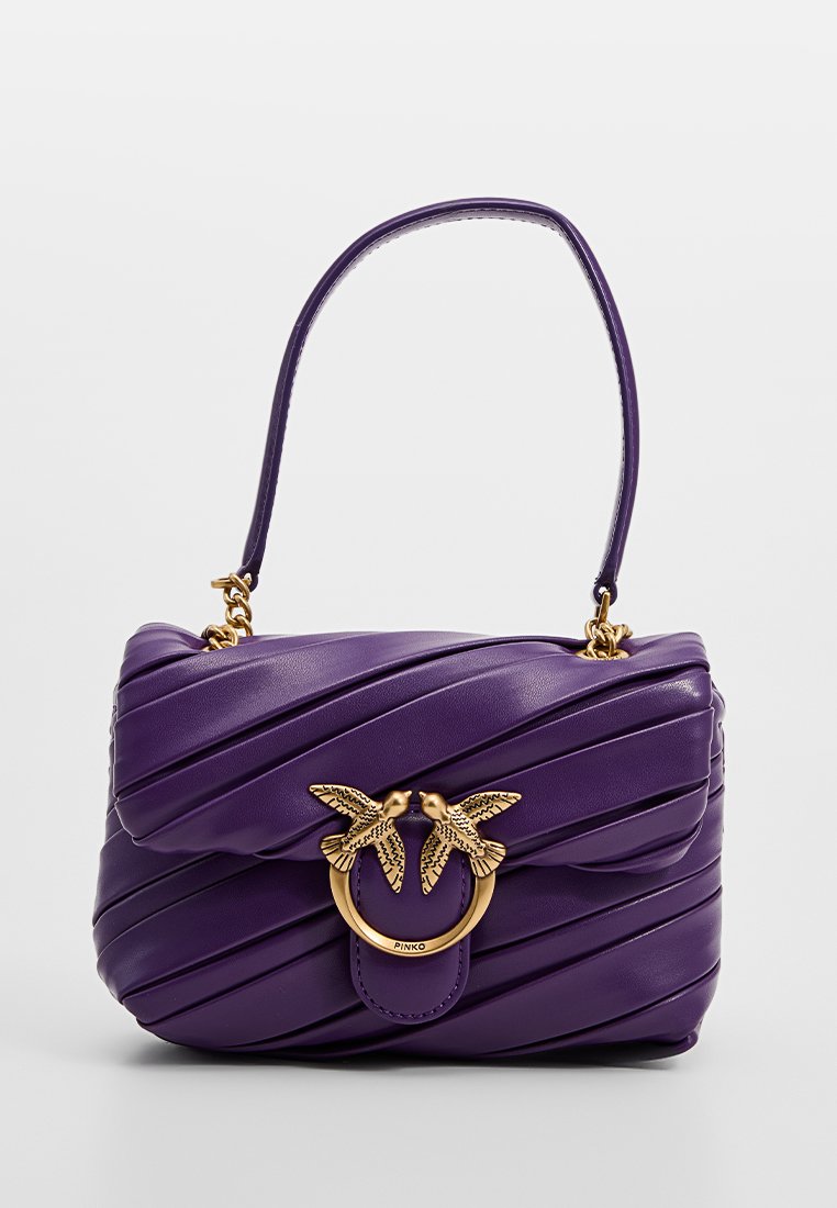 Sac à main en cuir violet avec des plis diagonaux, doté d'un accent en métal doré représentant deux oiseaux et un contour circulaire à l'avant.