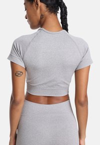 Szary krótki top sportowy z krótkimi rękawami, z okrągłym dekoltem i elastycznym materiałem. Posiada gładką fakturę i dopasowany krój.