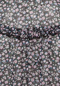 Vestido negro floral com decote em babados, apresentando flores rosas e azuis num tecido texturizado. Padrão floral leve e delicado por toda a peça.