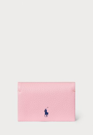 Pink leather cardholder with a textured finish, featuring a navy logo accent. Compact shape with gold-tone hardware details.
