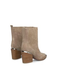 Beżowe botki na kostkę z ekoskóry o ribbowanym wzorze, z ostrym noskiem i masywnym, warstwowym obcasem w wyglądzie drewna.