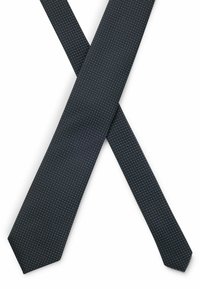 Cravate bleu marine avec un motif texturé comportant de petits points blancs uniformément espacés, se rétrécissant vers une extrémité pointue. Le matériau semble lisse et tissé.