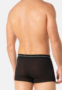 Boxer-briefs noirs avec de petits pois blancs, ceinture élastique avec marque, tissu doux, coupe ajustée et longueur mi-cuisse.