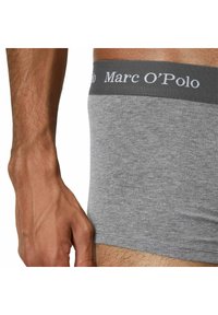 Boxer-briefs en coton gris avec une ceinture élastique gris foncé arborant le texte "Marc O'Polo" en blanc. Texture unie, design près du corps.