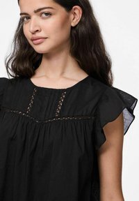 Blusa nera realizzata in tessuto leggero con maniche arricciate, dettagli plissettati e rifiniture in pizzo lungo il colletto e il corpino.