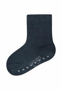 Calzino di cotone grigio scuro con parte superiore a coste, punta senza cuciture e grip in gomma a forma di stella sulla suola. Presenta un logo grigio chiaro vicino al tallone.