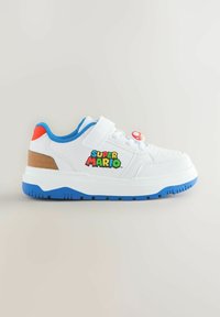 Weiße Kindersneaker mit blauer Sohle, rotem Absatz, "Super Mario"-Logo an der Seite und einem roten Pilzanhänger an den weißen Schnürsenkeln.