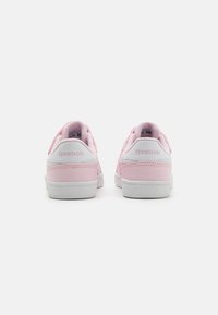 Lyserøde Reebok sneakers med en glat ruskindsoverdel, hvide accenter på hælen og sålen, flade snørebånd og logo bagpå.