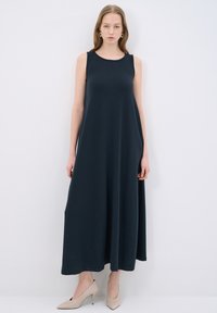 Abito lungo senza maniche di colore blu navy, realizzato in tessuto morbido, con un taglio rilassato e scollatura rotonda, caratterizzato da tasche laterali e orlo a pavimento.