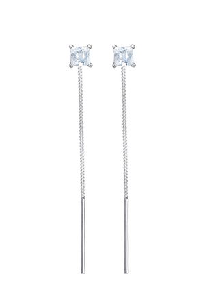 Paire de boucles d'oreilles argentées à enfiler avec des pierres carrées claires et des chaînes fines se terminant par des tiges élancées.