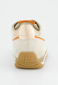 Sneakers en daim beige avec des accents orange, dotées d'un empiècement de talon en métal doré et d'une semelle en caoutchouc texturée. Logo gaufré à l'arrière.