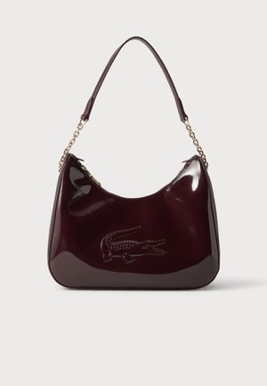 Sac à épaule en cuir verni bordeaux foncé avec détails en chaîne dorée et logo crocodile embossé sur le devant.