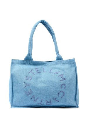 Borsa tote in denim azzurro chiaro con manici lunghi e borchie viola che formano un logo circolare "Stella McCartney" su un lato.