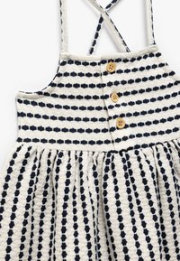 Abito leggero in cotone con motivo a righe navy e bianche, dotato di tre bottoni in legno sul davanti e spalline incrociate sul retro.