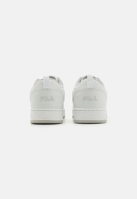 Ett par vita FILA-sneakers som visas från baksidan, med broderad logotyp på hälen och dragflikar högst upp.