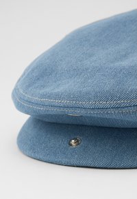 Világoskék farmer sapka strukturált fejrészsel és ívelt féknyéllel, kontrasztos varrással és ezüst színű patent részlettel.