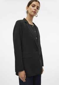 Black blazer with a tailored design, single-button closure, and two side pockets. Smooth fabric and long sleeves.