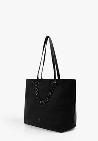 Bolso tote negro, fabricado en material liso, con un acento de eslabones de cadena en los asas y un pequeño logo en la base. Forma cuadrada con correas largas.