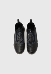 Melni slip-on stila apavi ar teksturētu augšpusi, izceļoties ar izliektām līnijām un gludu apdari. Papildināti ar cilpām papēžos ērtai vilkšanai.