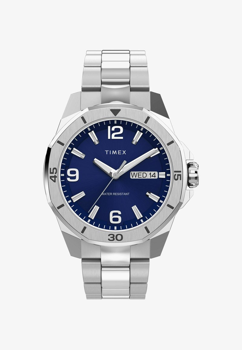 Reloj de acero inoxidable con esfera azul, grandes índices horarios blancos, indicador de fecha y pulsera plateada. Presenta resistencia al agua y un diseño audaz.